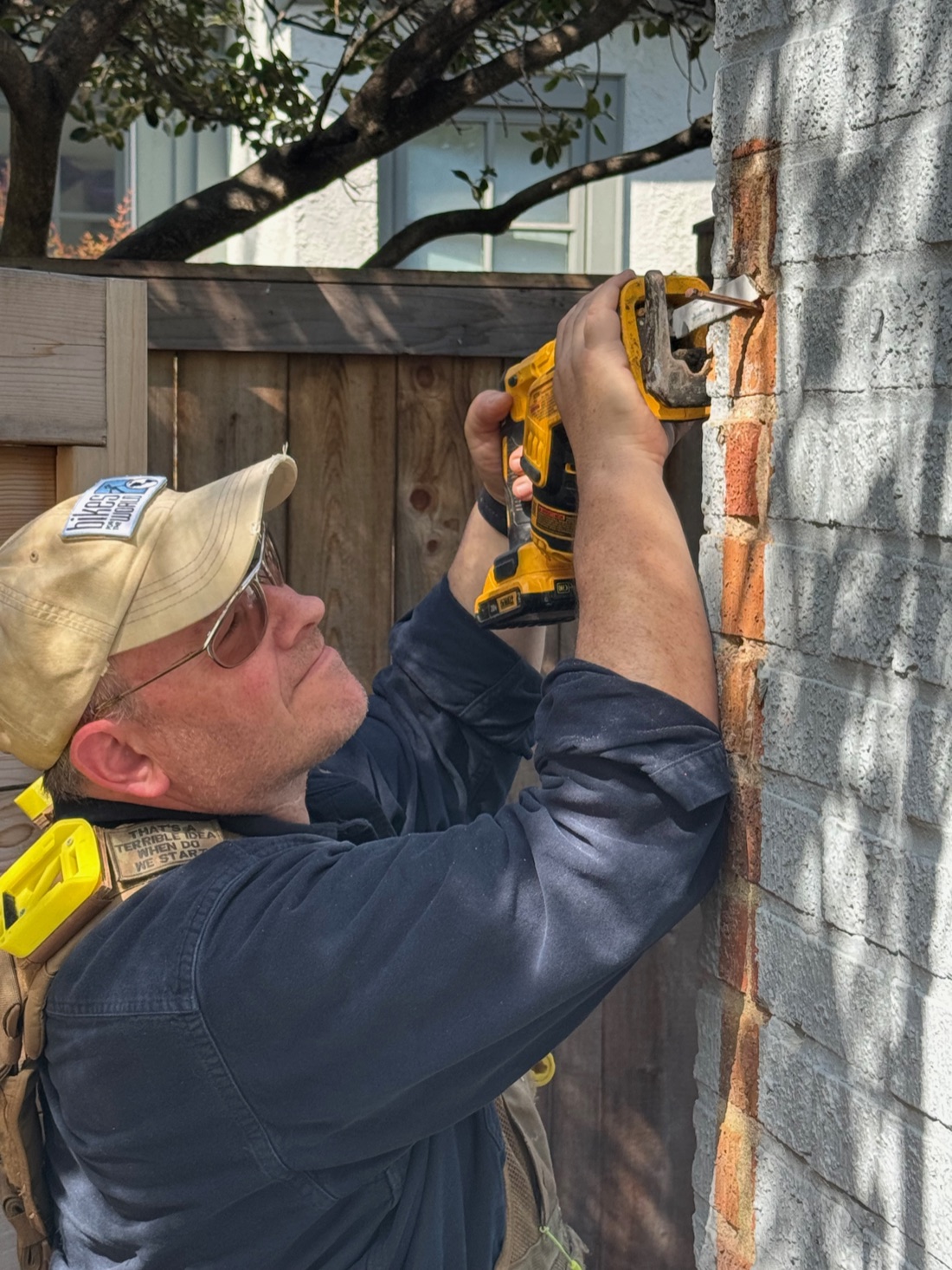 John Burg drilling into brick with a DeWalt driver on a job site